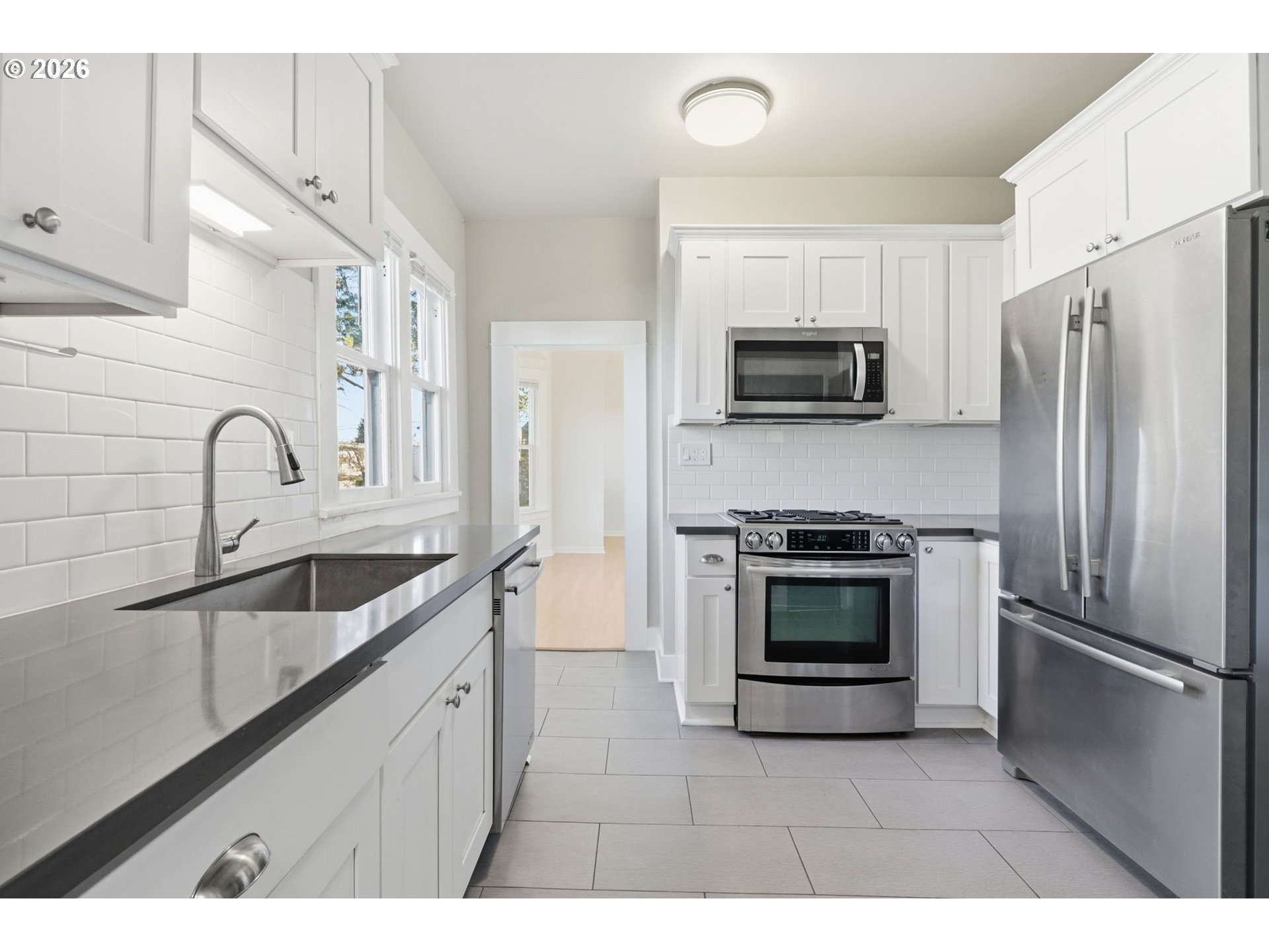 25 Southeast 76th Avenue Portland, OR 97215 - Photo 20 of 48 a kitchen with stainless steel appliances granite countertop a refrigerator a stove a sink and a microwave