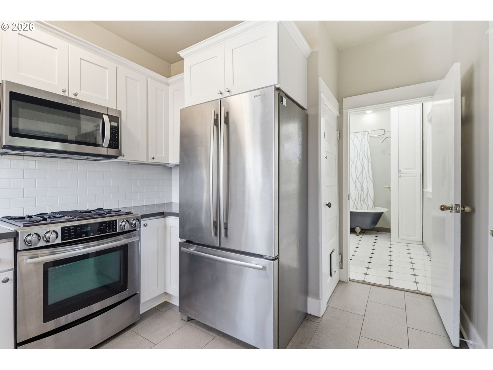 25 Southeast 76th Avenue Portland, OR 97215 - Photo 21 of 48 a kitchen with stainless steel appliances a refrigerator a stove a microwave and cabinets