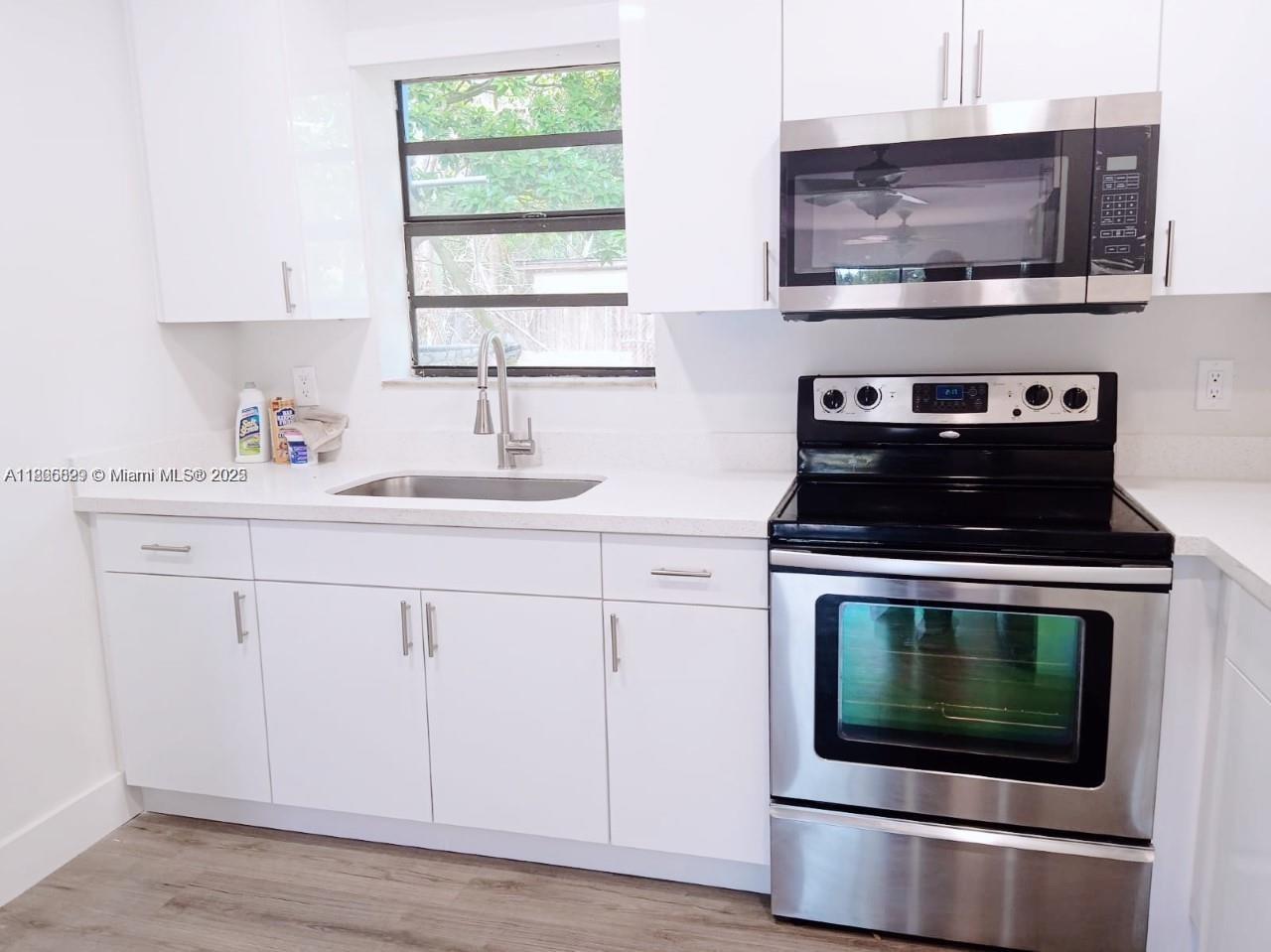 15061 Southwest 296th Street Homestead, FL 33033 - Photo 4 of 15 a kitchen with stainless steel appliances a stove microwave and sink