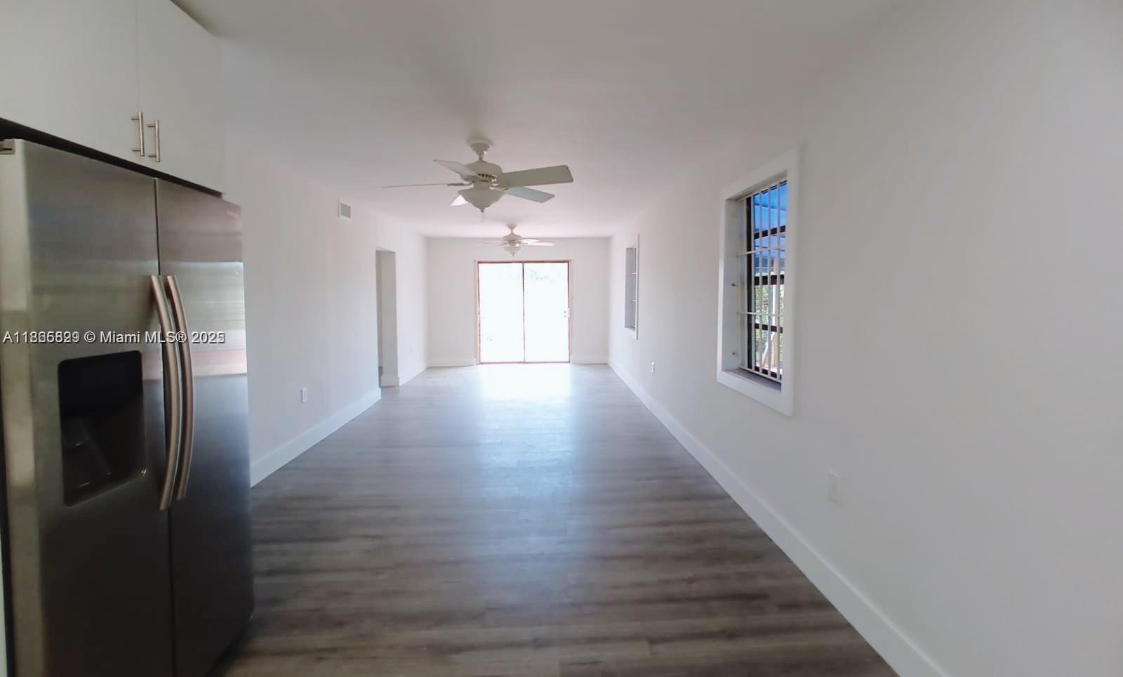 15061 Southwest 296th Street Homestead, FL 33033 - Photo 5 of 15 a view of an empty room with wooden floor and a window