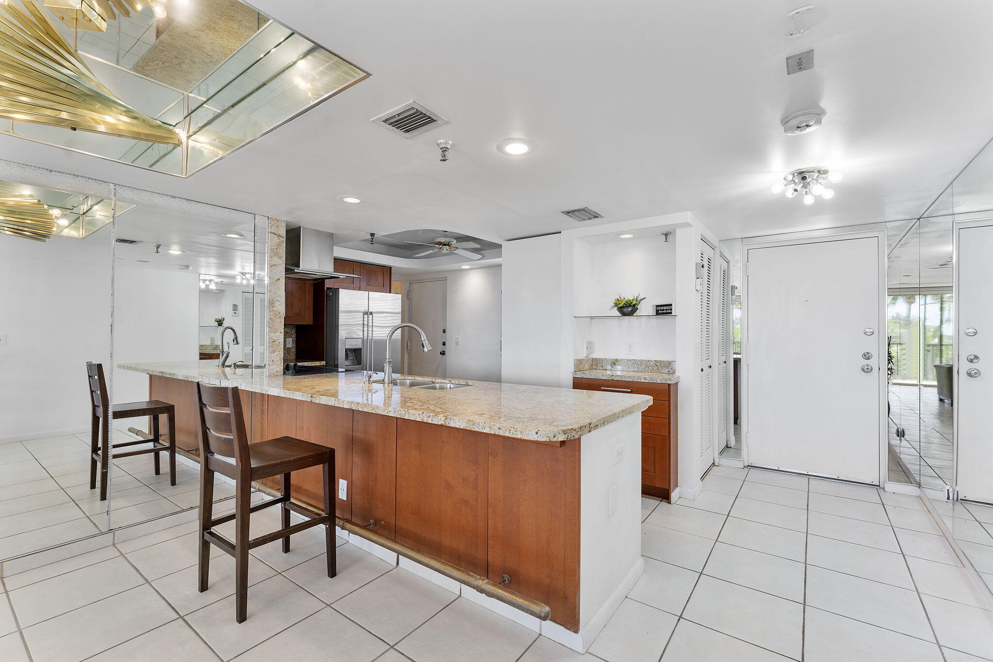 6500 Northwest 2nd Avenue, Unit 511 Boca Raton, FL 33487 - Photo 9 of 28 a large kitchen with cabinets chairs and refrigerator