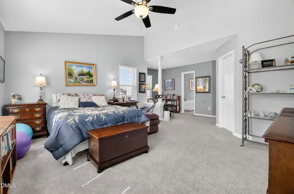 a spacious bedroom with a bed and ceiling fan