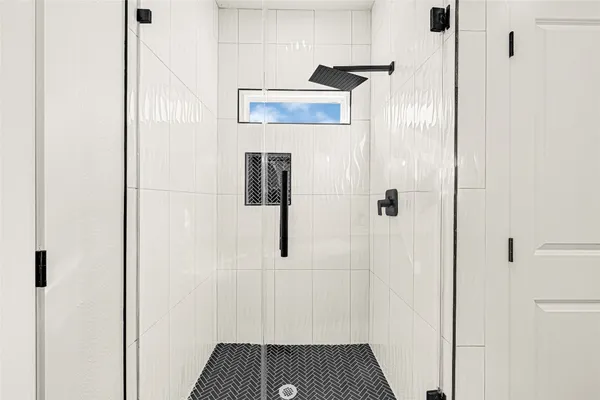 an empty room with ceiling fan and windows