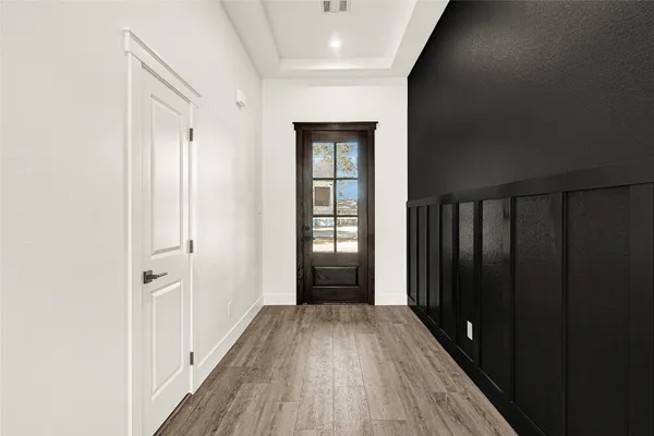 an empty room with wooden floor ceiling fan and windows
