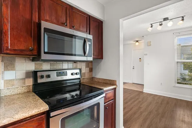 a kitchen with granite countertop cabinets stainless steel appliances and wooden floor