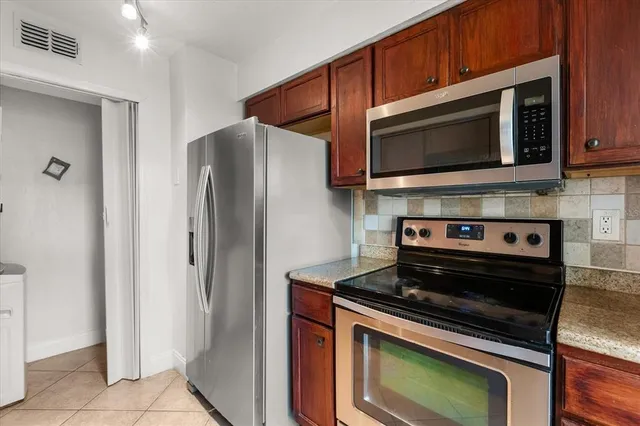 a kitchen with stainless steel appliances a stove microwave and refrigerator
