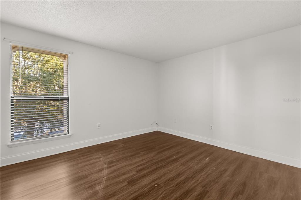 512 Orange Drive, Unit 32 Altamonte Springs, FL 32701 - Photo 4 of 16 a view of an empty room with wooden floor and a window