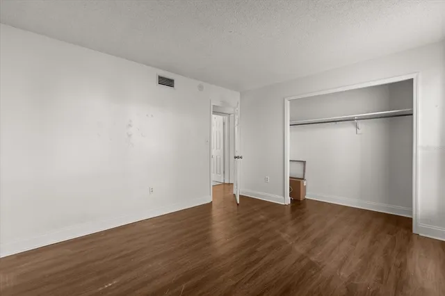 a view of an empty room with wooden floor