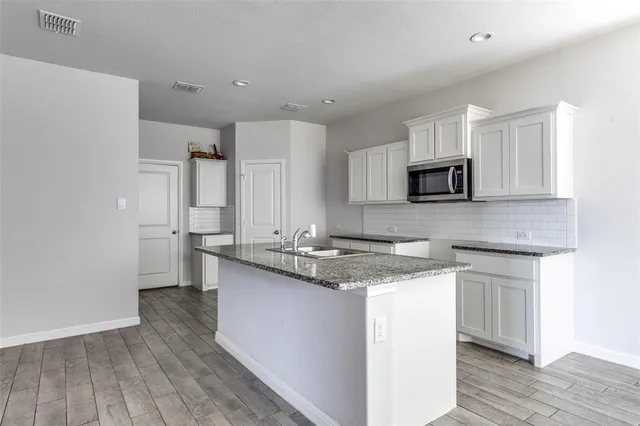 a kitchen with stainless steel appliances granite countertop a sink stove and microwave