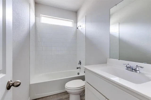 a bathroom with a bathtub shower sink vanity and toilet