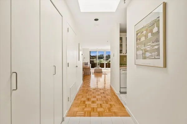 a view of a hallway with wooden floor and a living room