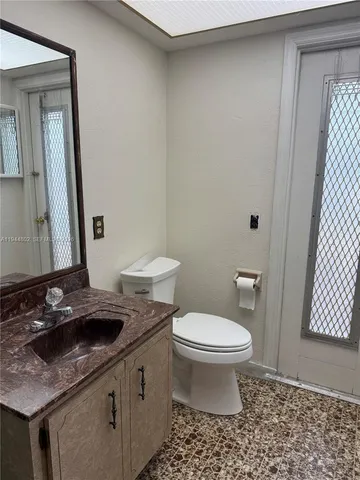 a bathroom with a granite countertop sink a toilet and shower