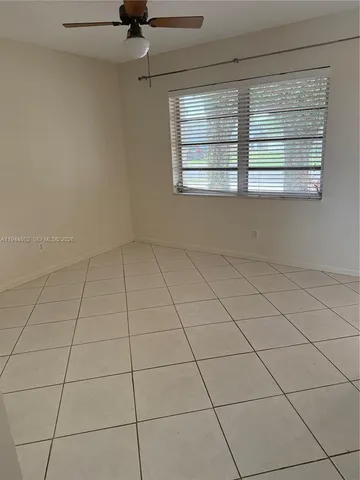 a view of a livingroom with wooden floor and a ceiling fan
