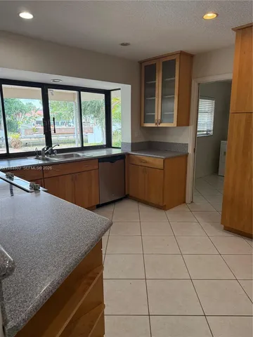 a kitchen with a sink a counter top space and stainless steel appliances