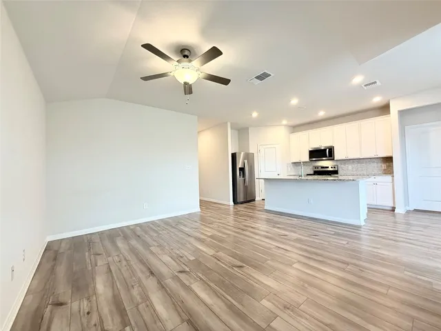 a view of kitchen with granite countertop cabinets and refrigerator