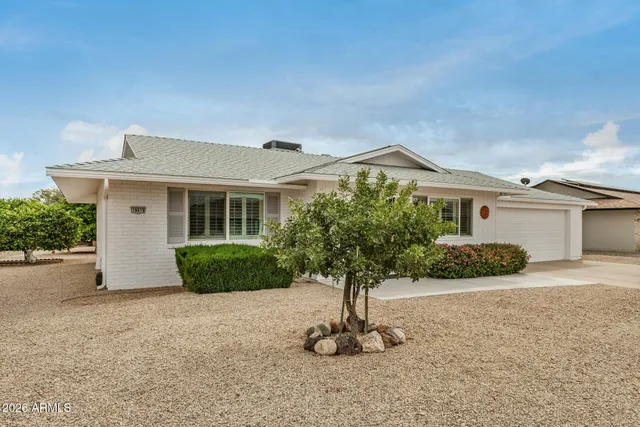a front view of a house with a yard and potted plants