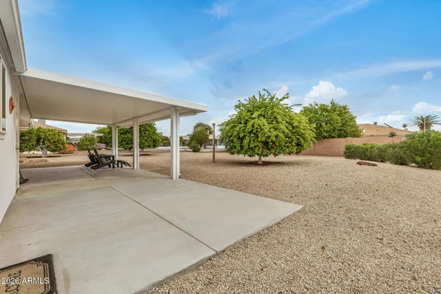 a view of a patio with a table and chairs under an umbrella