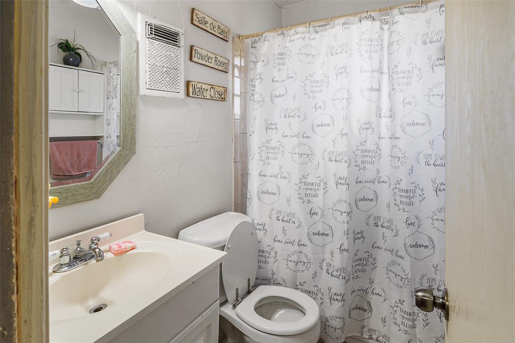 1129 Ridgeview Street Mesquite, TX 75149 - Photo 11 of 14 a bathroom with a sink a toilet and a mirror