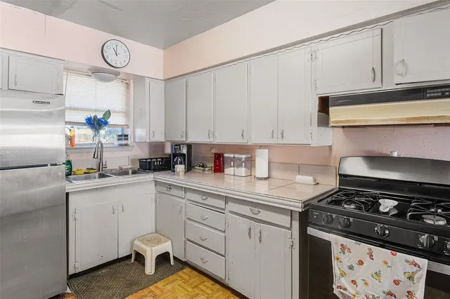 a kitchen with white cabinets and appliances