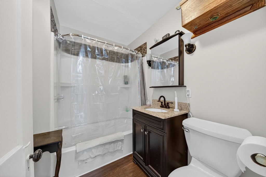 18 Maple Street Fairhaven, MA 02719 - Photo 20 of 39 a bathroom with a granite countertop sink toilet a mirror and shower