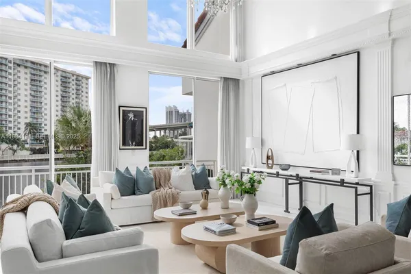a living room with furniture potted plant and a large window