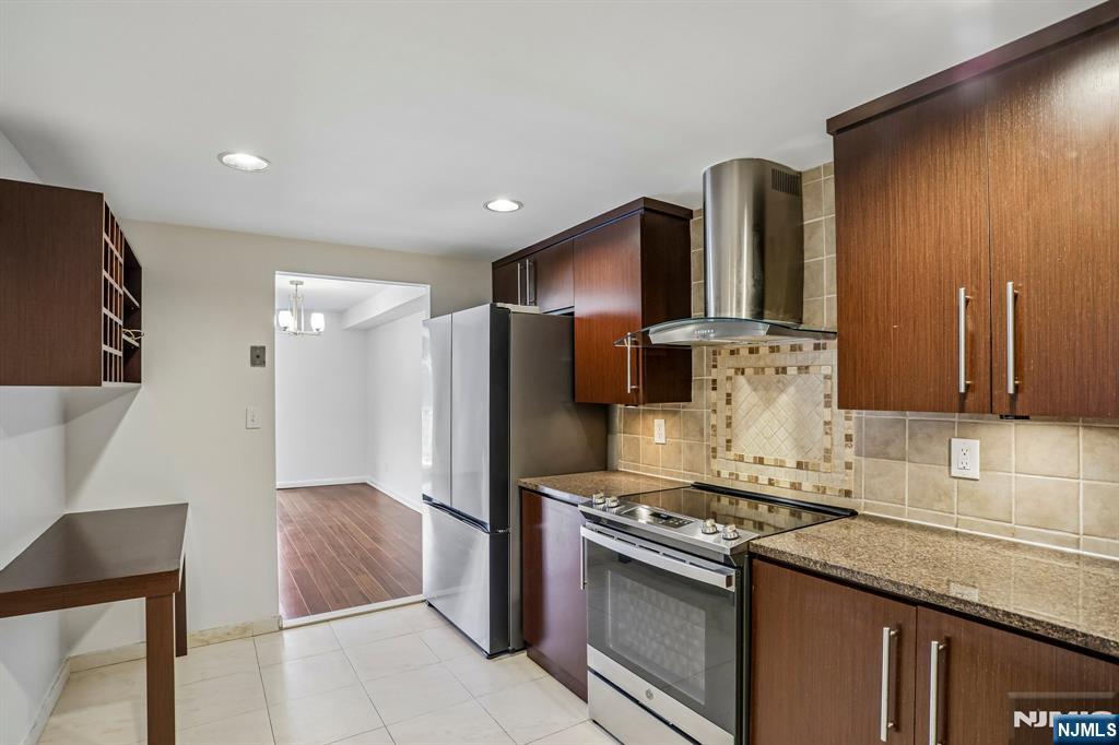 1077 River Road, Unit 1013 Edgewater, NJ 07020 - Photo 11 of 24 a kitchen with stainless steel appliances granite countertop a refrigerator and a stove top oven