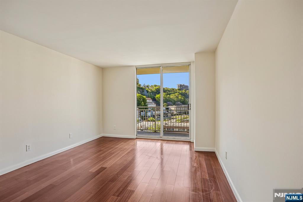 1077 River Road, Unit 1013 Edgewater, NJ 07020 - Photo 13 of 24 wooden floor in an empty room with a window