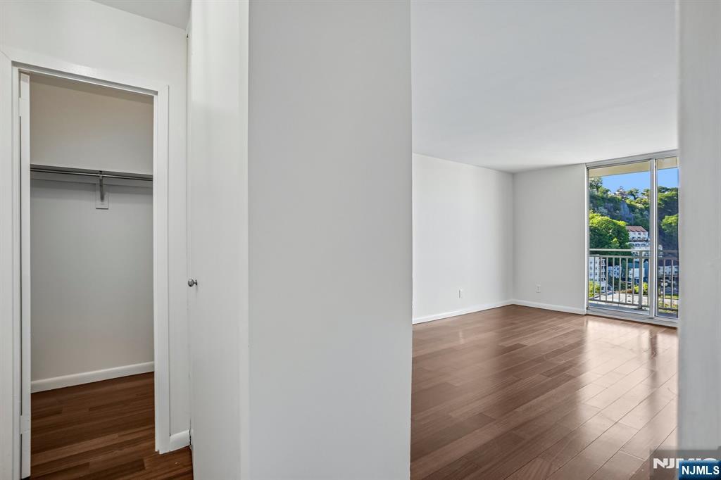 1077 River Road, Unit 1013 Edgewater, NJ 07020 - Photo 16 of 24 a view of an empty room with wooden floor and a window