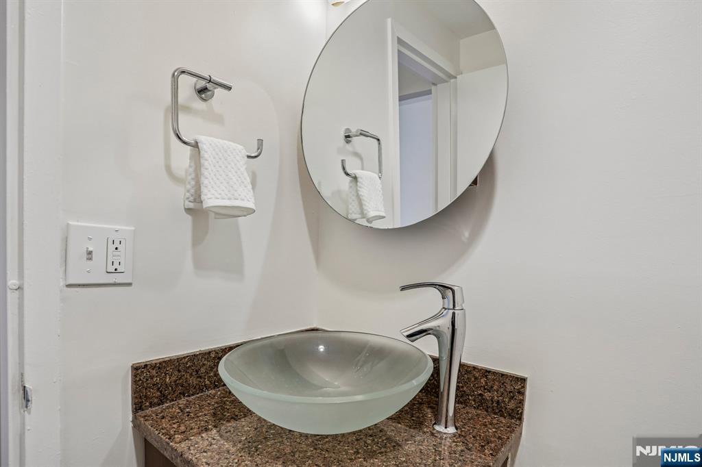 1077 River Road, Unit 1013 Edgewater, NJ 07020 - Photo 20 of 24 a bathroom with a sink and mirror