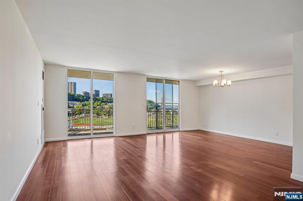1077 River Road, Unit 1013 Edgewater, NJ 07020 - Photo 2 of 24 a view of an empty room with wooden floor and a window