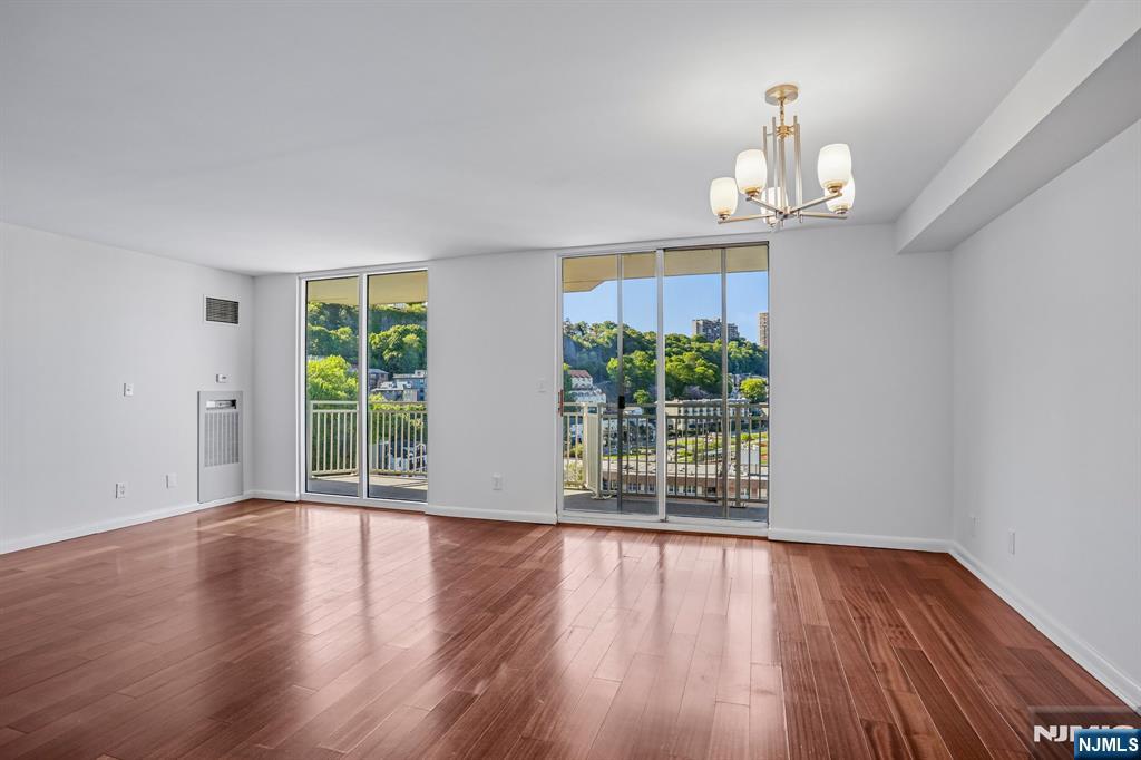 1077 River Road, Unit 1013 Edgewater, NJ 07020 - Photo 3 of 24 a view of an empty room with wooden floor and a window