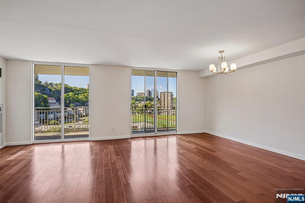 1077 River Road, Unit 1013 Edgewater, NJ 07020 - Photo 4 of 24 a view of an empty room with wooden floor and a window