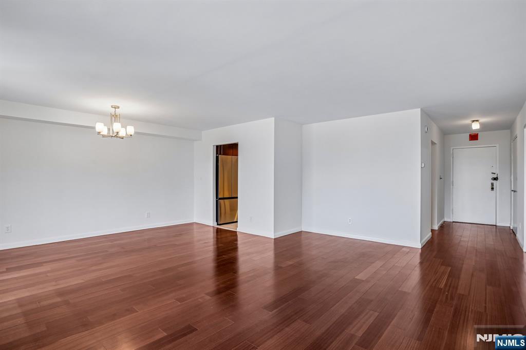 1077 River Road, Unit 1013 Edgewater, NJ 07020 - Photo 5 of 24 a view of an empty room with wooden floor and a ceiling fan