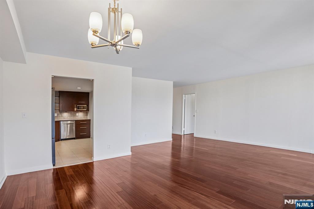 1077 River Road, Unit 1013 Edgewater, NJ 07020 - Photo 6 of 24 a view of an empty room with wooden floor and a window