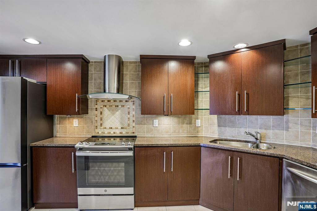 1077 River Road, Unit 1013 Edgewater, NJ 07020 - Photo 9 of 24 a kitchen with stainless steel appliances granite countertop a sink and a refrigerator