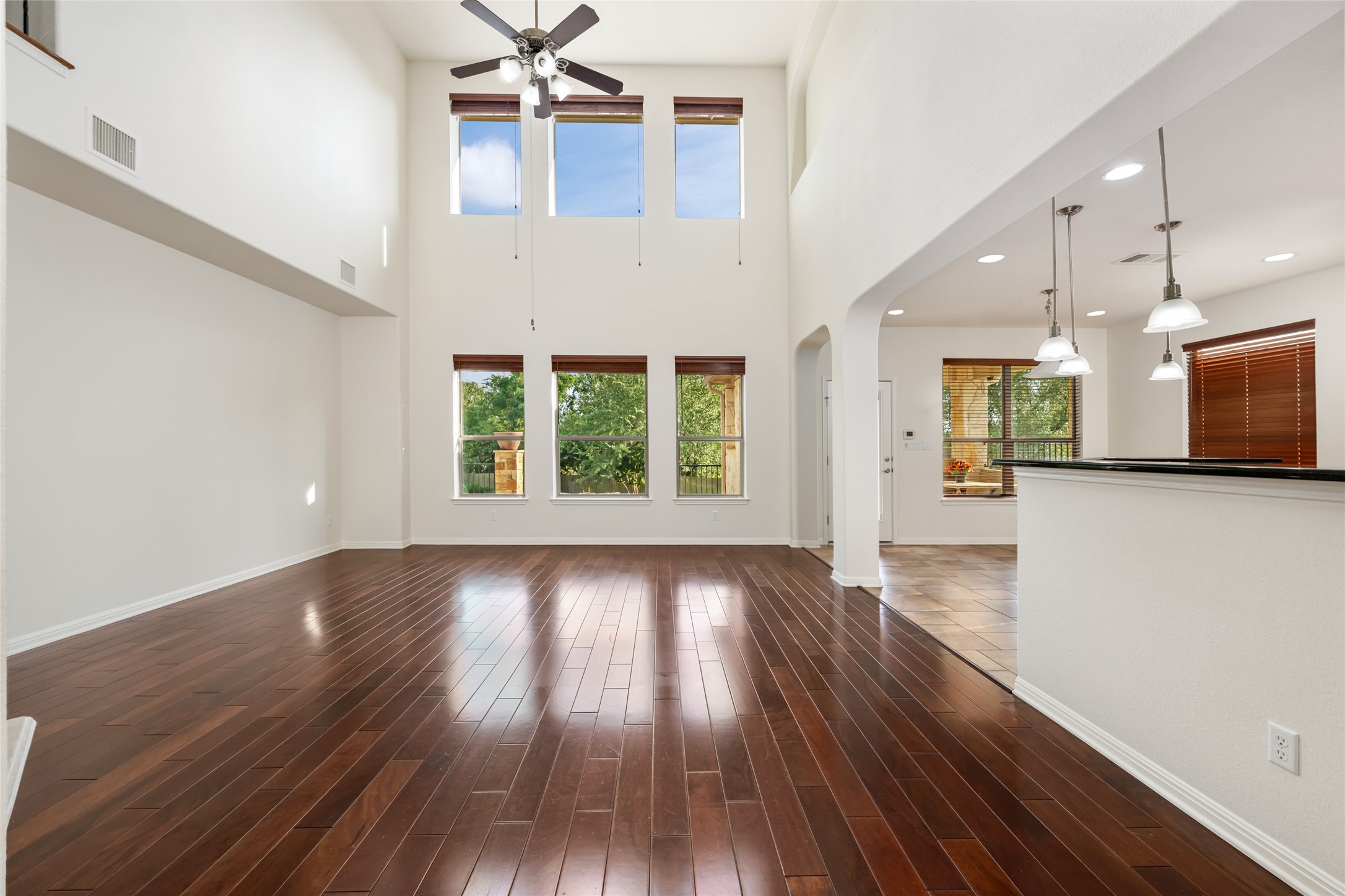 15205 Spillman Ranch Loop Austin, TX 78738 - Photo 14 of 40 A spacious living area boasts towering ceilings and rich hardwood flooring, inviting abundant natural light.