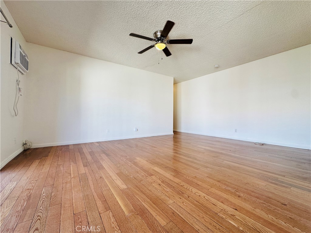 4146 Elm Avenue, Unit 5 Long Beach, CA 90807 - Photo 3 of 24 a view of an empty room with wooden floor and a ceiling fan