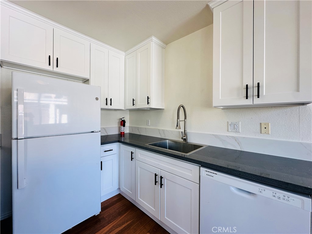 4146 Elm Avenue, Unit 5 Long Beach, CA 90807 - Photo 5 of 24 a kitchen with granite countertop white cabinets and white appliances