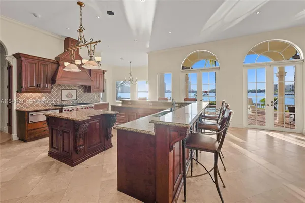 a kitchen with stainless steel appliances granite countertop a stove top oven a dining table and chairs with wooden floor