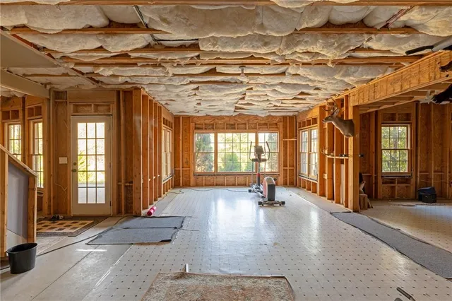 a living room with furniture floor to ceiling window and wooden floor