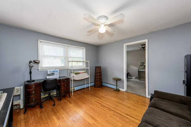a view of a workspace with furniture and a window