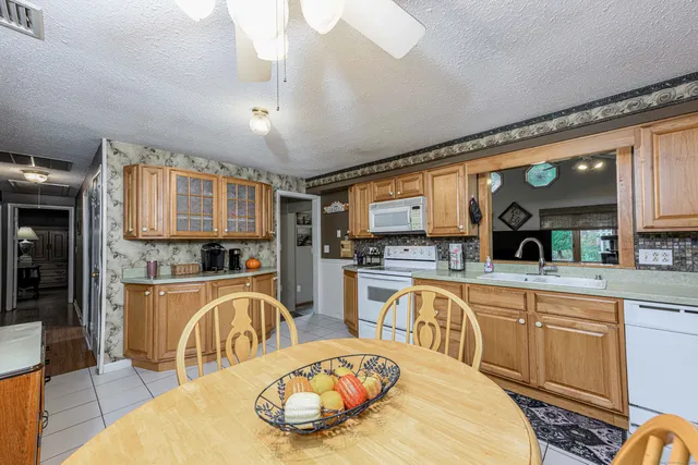 a kitchen with stainless steel appliances granite countertop a sink and wooden cabinets