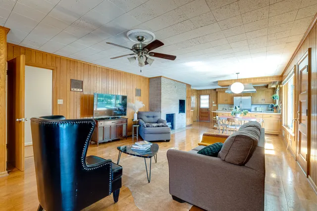 a living room with furniture a ceiling fan and a window