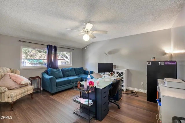 a bedroom with a bed couch and large window