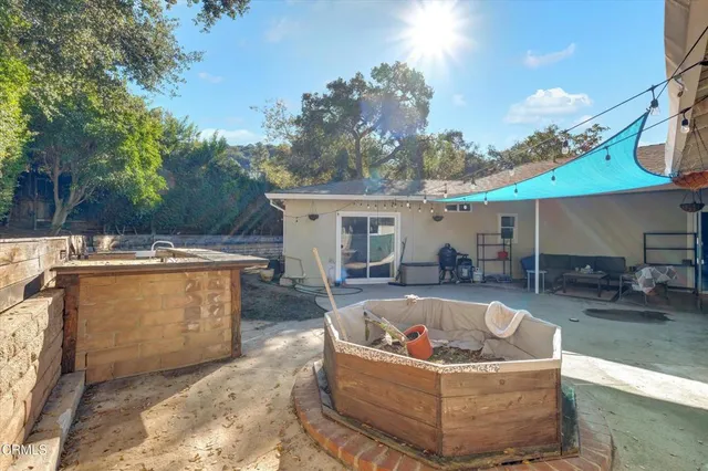 a view of a house with a backyard and seating area