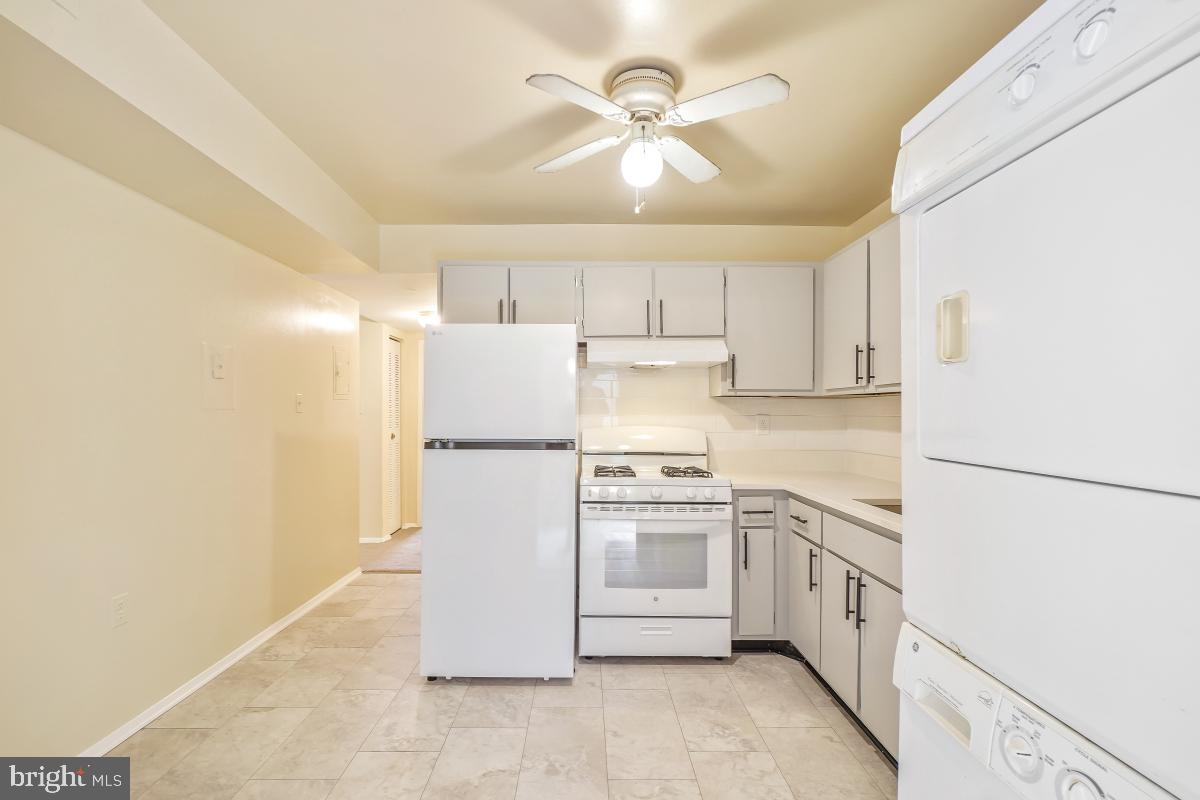 18610 Walkers Choice Road, Unit 18610 Gaithersburg, MD 20886 - Photo 17 of 30 a kitchen with white cabinets and white appliances