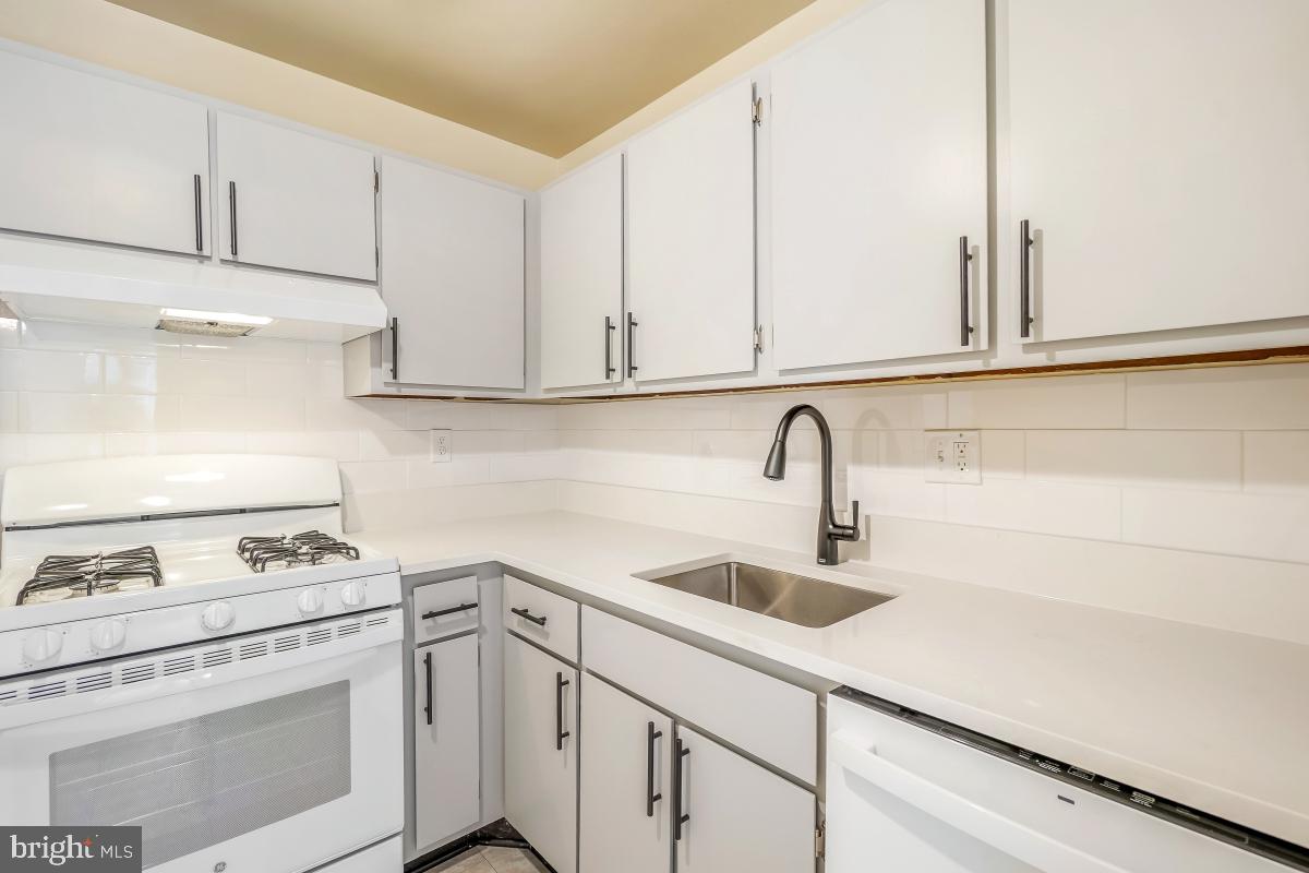 18610 Walkers Choice Road, Unit 18610 Gaithersburg, MD 20886 - Photo 19 of 30 a kitchen with white cabinets and appliances