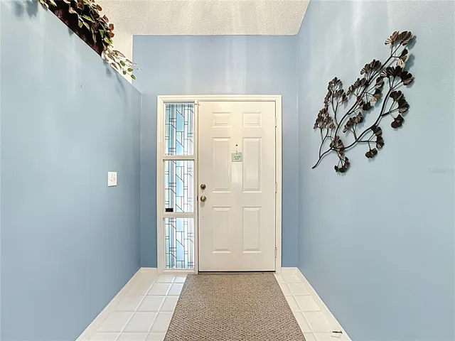 a living room with furniture a ceiling fan a lamp and a window