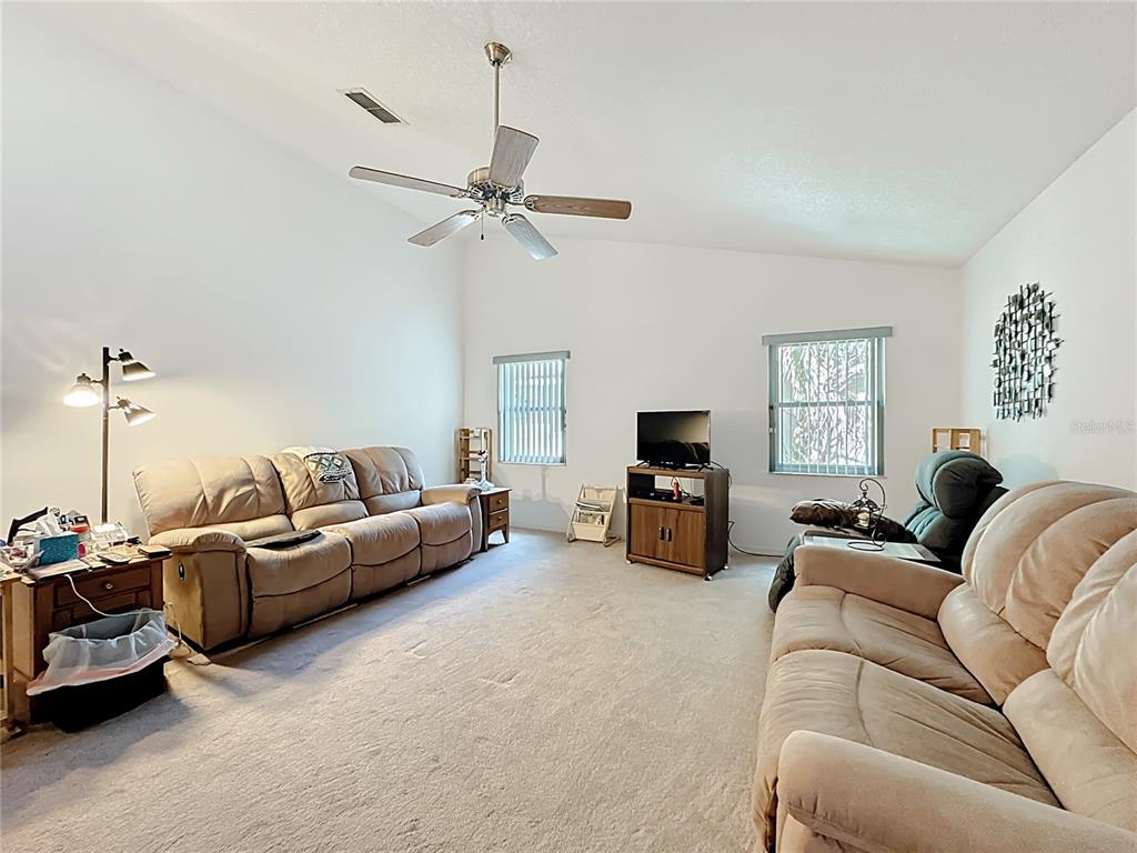 Undisclosed Address Winter Springs, FL 32708 - Photo 15 of 66 a living room with furniture a ceiling fan a lamp and a window