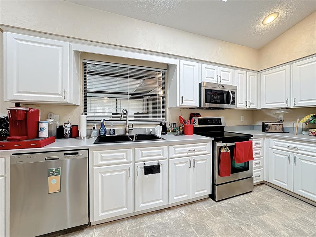 Undisclosed Address Winter Springs, FL 32708 - Photo 20 of 66 a kitchen with white cabinets sink and stainless steel appliances